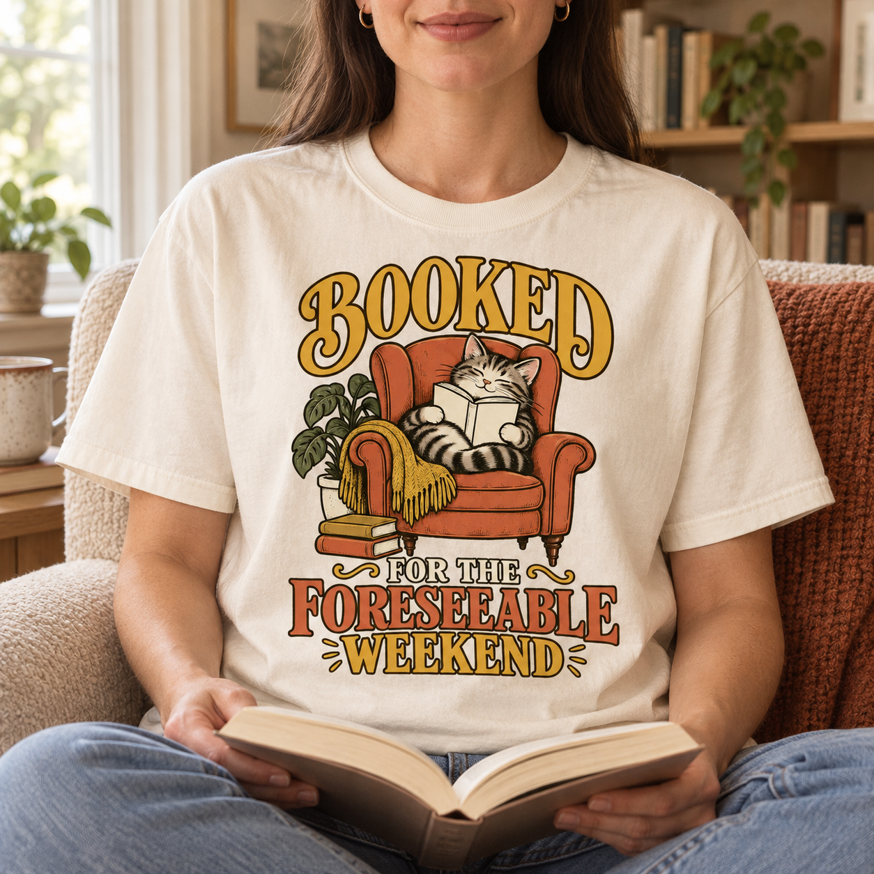 Woman wearing the Booked for the Foreseeable Weekend tee in a reading nook