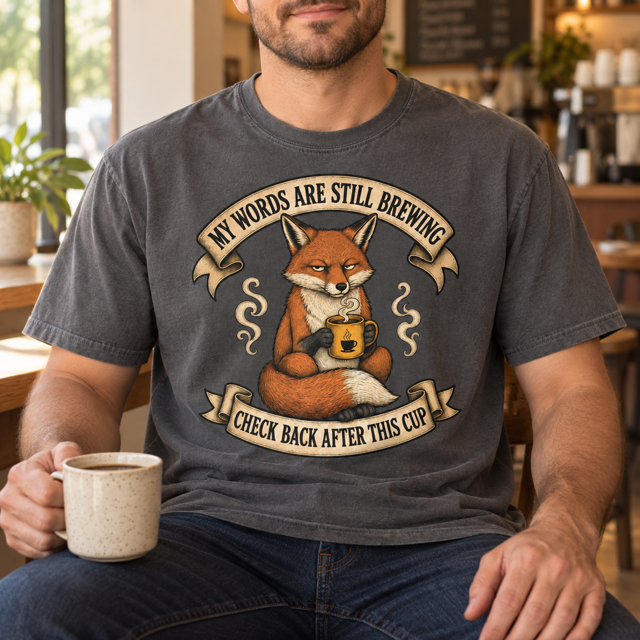 Man wearing the My Words Are Still Brewing coffee tee in a cafe